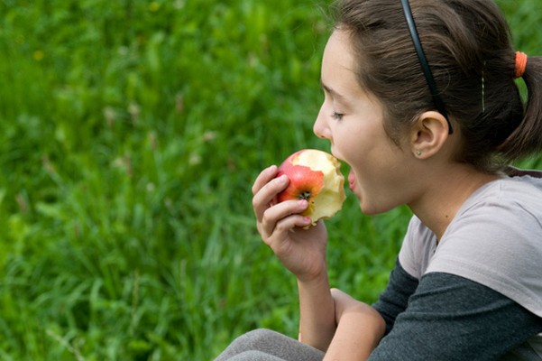 Девочка ест яблоко 